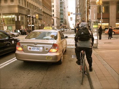 سائق دراجة يواجه إشارة وبالوعة وسيارة عند فتح الإشارة